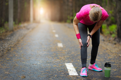 Joggerin hält sich schmerzendes Knie