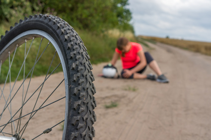 Gestürzte Radfahrerin hält sich verletztes Knie