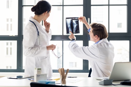 Ein Arzt und eine Ärztin besprechen eine Röntgenaufnahme