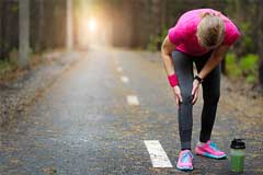 Joggerin hält sich schmerzendes Knie